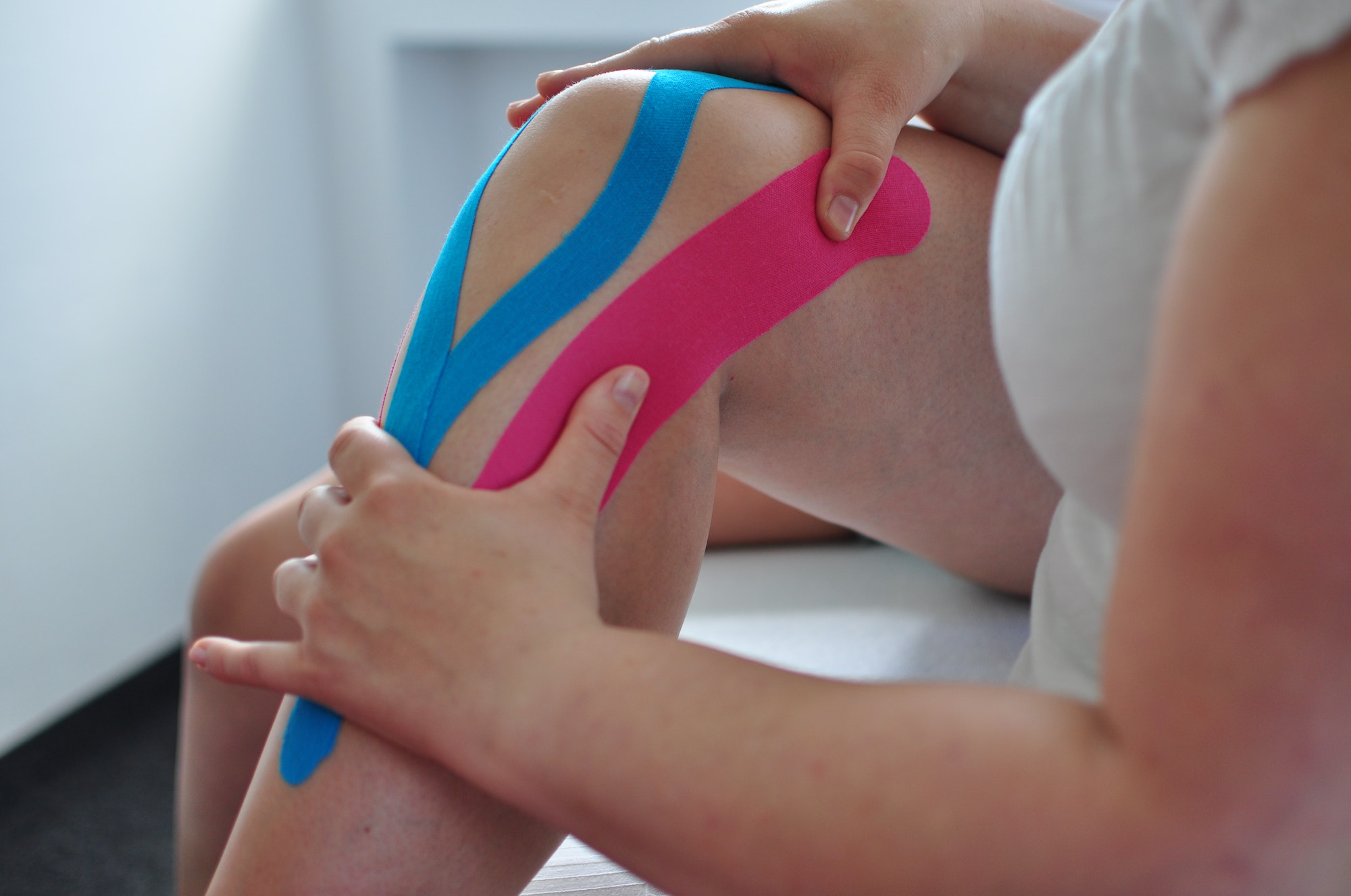 knee-treatment-massaging-the-leg-and-knee-kinesiology-tapes